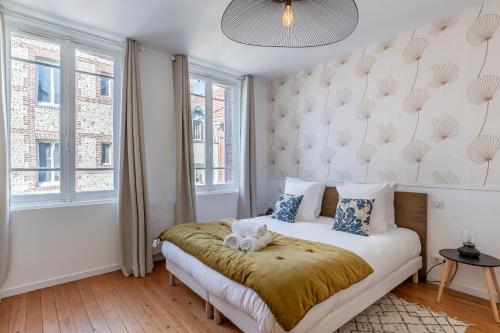 une chambre avec un lit avec un ours en peluche dessus dans l'établissement La Suite - Honfleur, à Honfleur