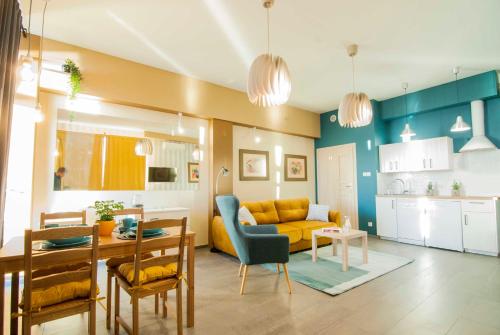 salon z żółtą kanapą i stołem w obiekcie Na Klifie Cafe Apartament w mieście Ustronie Morskie