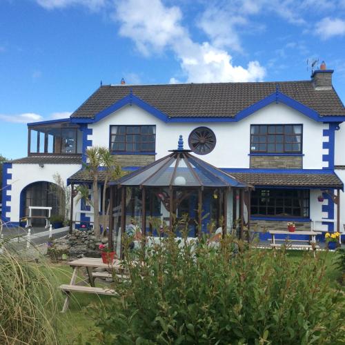 a house with a gazebo in front of it at Barkers Accommodation in Spanish Point
