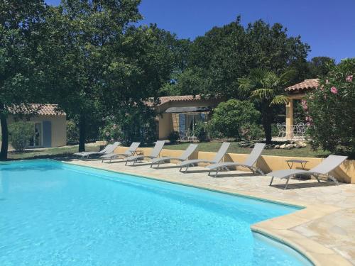 - une rangée de chaises longues à côté de la piscine dans l'établissement Le Clos des Cigales, à Roussillon