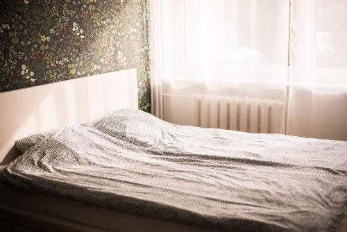 1 cama no hecha en un dormitorio con ventana en Põllupesa en Haapsalu