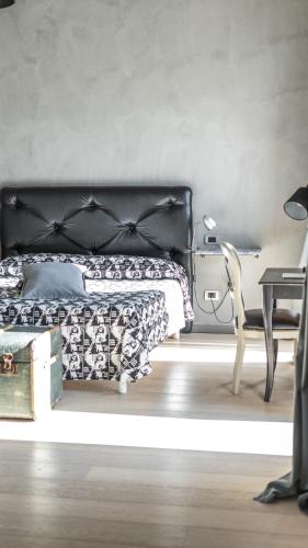a bedroom with a bed and a table and a chair at Agriresort Villa Gelso- Adults Friendly in Vesime