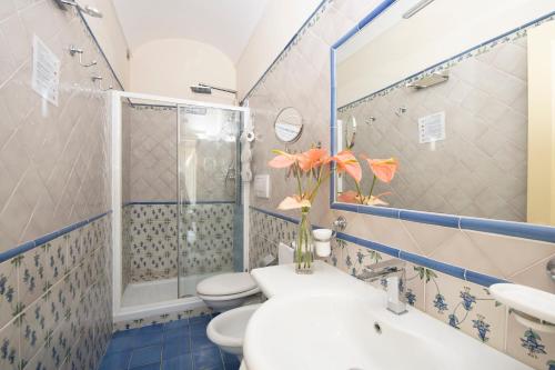 e bagno con servizi igienici, doccia e lavandino. di Residenza Del Duca Rooms & Apartments ad Amalfi
