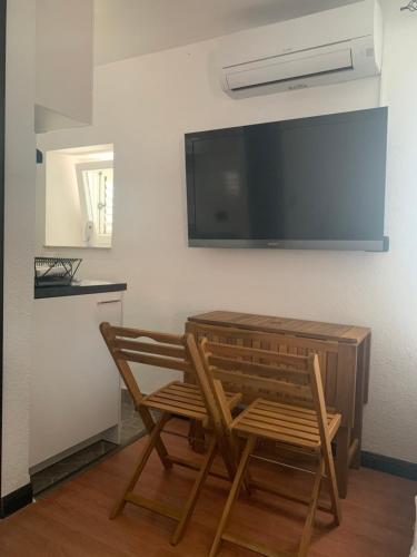 une table et deux chaises et une télévision sur un mur dans l'établissement Studio Urban, à Piran