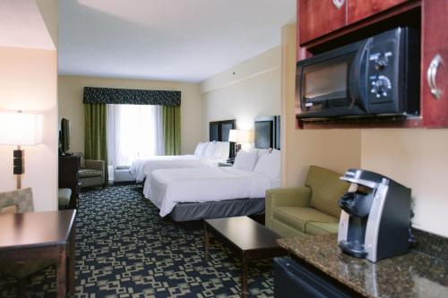 a hotel room with two beds and a tv at Holiday Inn Express Hotel Raleigh Southwest, an IHG Hotel in Raleigh