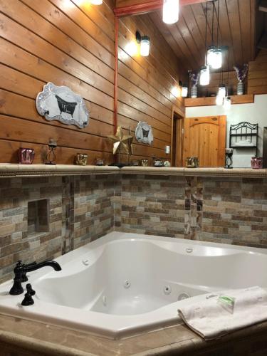 una gran bañera blanca en una habitación con paredes de madera. en Dunes Motel - Bend, en Bend