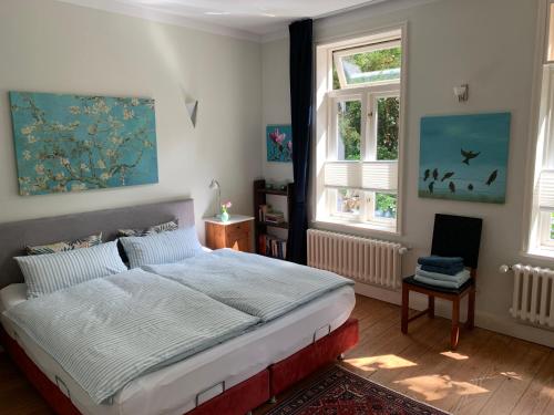 a bedroom with a large bed and two windows at Waldmühle in Schleswig