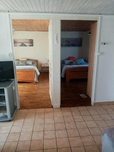 a room with two beds and a room with a tv at entre mer et campagne in Damgan