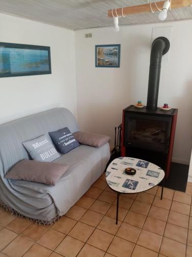 a living room with a couch and a fireplace at entre mer et campagne in Damgan