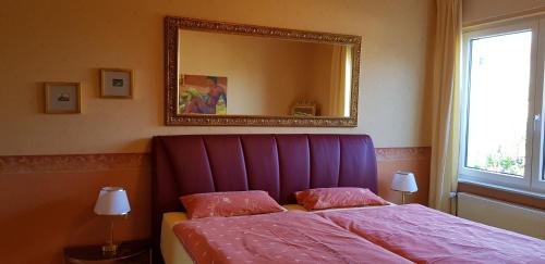 a bedroom with a purple bed and a mirror at Ferienwohnungen Gronen in Boppard
