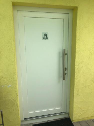 una puerta blanca con un letrero junto a una pared amarilla en Gästehaus Glock II, en Marbach am Neckar