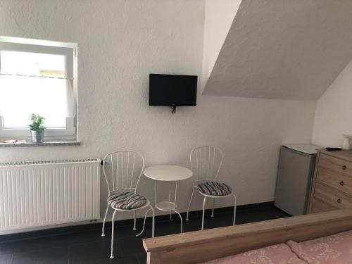 a room with two chairs and a table and a television at Gästehaus Glock II in Marbach am Neckar