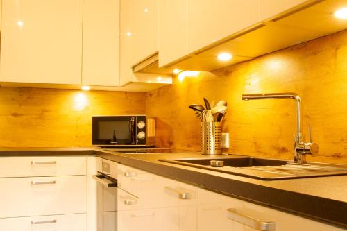 a kitchen with a sink and a microwave at Landhaus Mair in Scharnitz