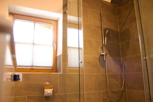 a bathroom with a shower with a glass door at Landhaus Mair in Scharnitz