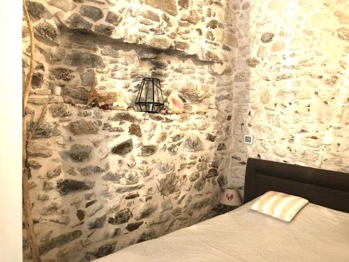 a bedroom with a stone wall with a bed at Appartement de charme au coeur de Saint-Tropez in Saint-Tropez