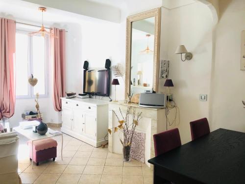 a living room with a tv and a mirror at Appartement de charme au coeur de Saint-Tropez in Saint-Tropez