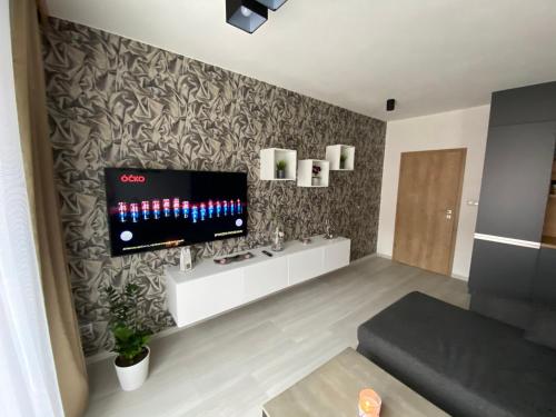 sala de estar con TV de pantalla plana en la pared en Apartmán Champion, en Plzeň