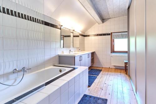 een badkamer met een bad en een wastafel bij Le Rocher Du Lac in Houffalize