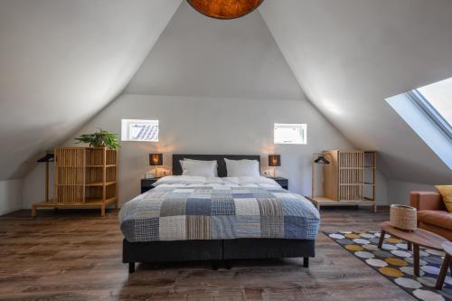 a bedroom with a large bed in a attic at Noorderhaecks Suites & Apartment in 't Horntje