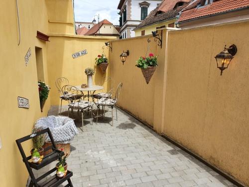 een terras met een tafel en stoelen in een binnenplaats bij Smiley Rezident in Sibiu