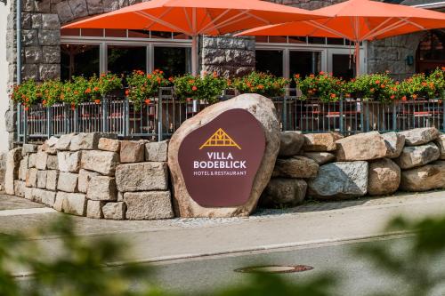 a sign in front of a building with an umbrella at Hotel Villa Bodeblick in Schierke