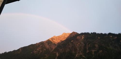 a mountain with the sun shining on it at Landhaus Almrausch in Mittelberg