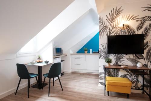 uma sala de estar com uma mesa e cadeiras e uma televisão em Le Carnot - HYPERCENTRE - Cosy & Climatisation em Cannes