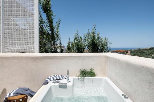 a bath tub with a faucet on a wall at Jasmine Holiday Villa in Episkopi
