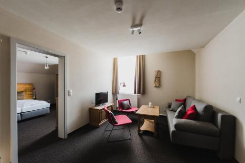 a hotel room with a couch and a desk and a bed at Hotel Villa Bodeblick in Schierke