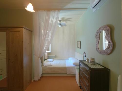 una camera con letto, specchio e cassettiera di Ioniso House a Vathi