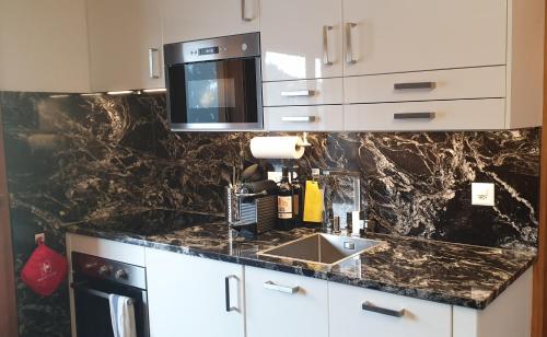 uma cozinha com um lavatório e um micro-ondas em Premium Jacuzzi Central Verbier Studio, High Floor em Verbier