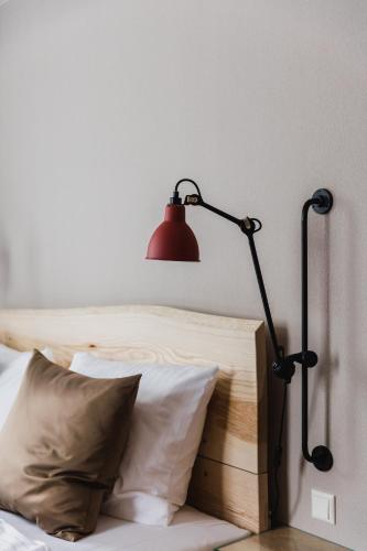 a red lamp sitting next to a bed with pillows at Hotel Villa Bodeblick in Schierke