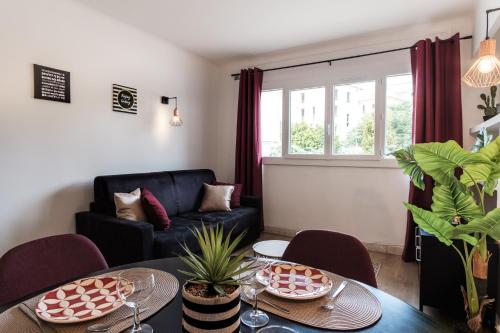 uma sala de estar com um sofá e uma mesa em Les Sorbiers - CENTRE VILLE - Spacieux & Climatisation em Cannes
