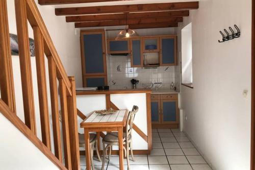 a kitchen with blue cabinets and a wooden table at Charmante maison de pêcheur in Barfleur