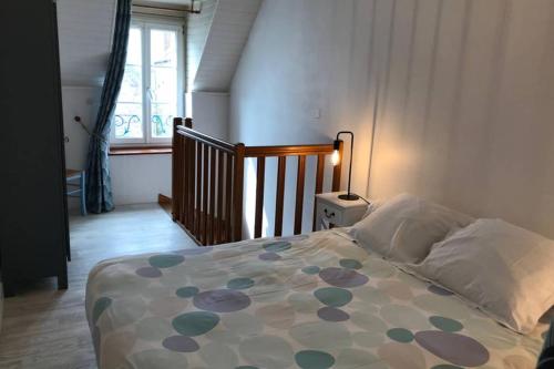 a bedroom with a bed with a polka dot blanket at Charmante maison de pêcheur in Barfleur