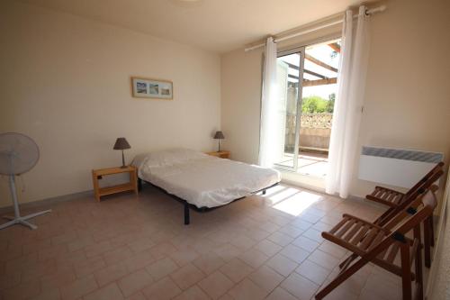 une chambre avec un lit et une grande fenêtre dans l'établissement A quelques pas de la plage Belle Maison de vacances, 6 à 8 couchages, 3 chambres, balcon, jardin, parking, 50 m de la mer- PORTIRAGNES PLAGE LXBOSQD, à Portiragnes