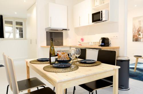 - une cuisine avec une table, une bouteille de vin et des verres dans l'établissement La Madeleine - Strasbourg, à Strasbourg