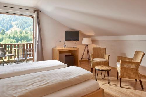 Habitación de hotel con cama y balcón en Hotel Bad Schwarzsee, en Bad-Schwarzsee