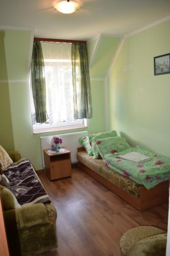 a bedroom with a bed and a window and a couch at U Rybaka (pokoje) in Jezierzany