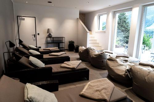 a living room with several couches and a staircase at Designhotel Sonnhof by Vitus Winkler in Sankt Veit im Pongau