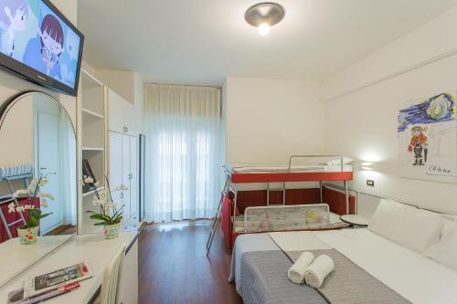 a bedroom with a bed and a tv in it at Hotel Adelphi in Riccione