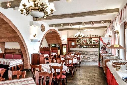 - un restaurant avec des tables et des chaises dans une salle dans l'établissement Hotel Rózsa Csárda Bungalow & Caravan Park, à Hegyeshalom