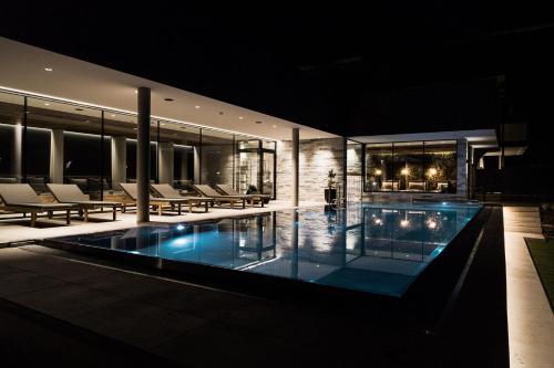 a house with a swimming pool at night at Designhotel Sonnhof by Vitus Winkler in Sankt Veit im Pongau
