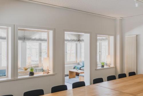 a dining room with a table and chairs and windows at Hotel Villa Bodeblick in Schierke