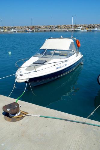 a white boat docked at a dock in the water at Christos Place-Anidri in Palaiochóra
