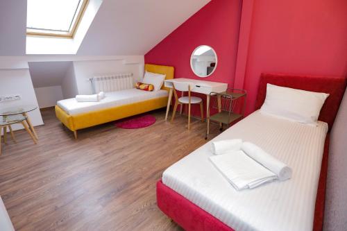 a small room with two beds and a table at Different Apartments in Niš