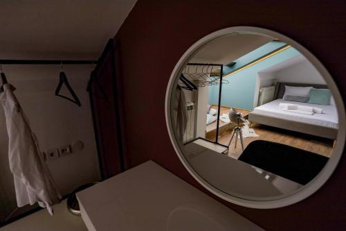 a mirror in a room with a bed and a bedroom at Different Apartments in Niš