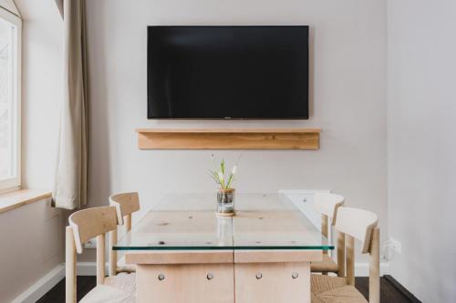 a dining room with a table and a tv on a wall at Hotel Villa Bodeblick in Schierke