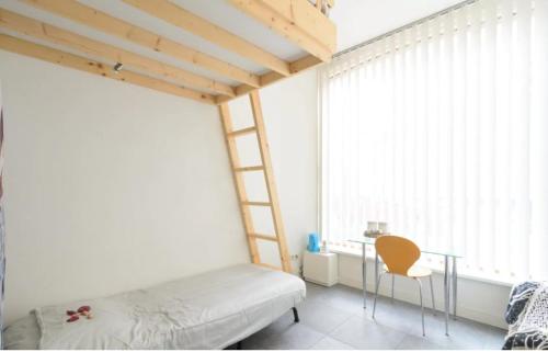 a bedroom with a bed and a desk and a window at Marijke's guestroom in Amsterdam