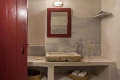 a bathroom with a sink and a mirror at The sculptor's house by Cycladica in Oia